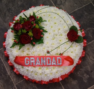 Based Posy - At Sarah Coxon Floral Design we are delighted to present this product available for flower delivery in Mid and North Norfolk. 

This traditional posy is based in white chrysanthemums and edged in a colour co-ordinated ribbon. The spray on top of the round posy includes Roses and foliage, this is linked with Bear grass to a single rose to complete the design. 

This stunning Posy arrangement which has been arranged in water retaining foam (oasis) to ensure maximum freshness. 

Standard - approx size 14" 

Deluxe - approx size 16"

Luxury - approx size 18"

We deliver directly to all of the local funeral directors and will contact them to confirm a delivery time. 

Our flowers at Sarah Coxon Floral Design arrive fresh from the Dutch auctions every day so you can be rest assured we are using the best quality of flowers available.

If you would like to choose a colour scheme, please state this in the special request box. Suggested colours are Red and White (as shown), Yellow and white, Pink and White and Peach and white. If no colours are requested we will make the posy in the pitcure.