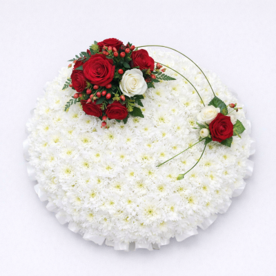 Based Posy - At Sarah Coxon Floral Design we are delighted to present this product available for flower delivery in Mid and North Norfolk. 

This traditional posy is based in white chrysanthemums and edged in a colour co-ordinated ribbon. The spray on top of the round posy includes Roses and foliage, this is linked with Bear grass to a single rose to complete the design. 

This stunning Posy arrangement which has been arranged in water retaining foam (oasis) to ensure maximum freshness. 

Standard - approx size 14" 

Deluxe - approx size 16"

Luxury - approx size 18"

We deliver directly to all of the local funeral directors and will contact them to confirm a delivery time. 

Our flowers at Sarah Coxon Floral Design arrive fresh from the Dutch auctions every day so you can be rest assured we are using the best quality of flowers available.

If you would like to choose a colour scheme, please state this in the special request box. Suggested colours are Red and White (as shown), Yellow and white, Pink and White and Peach and white. If no colours are requested we will make the posy in the pitcure.