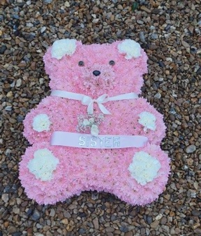 Large Teddy Bear - At Sarah Coxon Floral Design we are delighted to present this product available for flower delivery in Mid and North Norfolk. 

This specialised tribute is a Large Teddy Bear and is based in pink chrysanthemeums. The spray on the Teddy is a small cluster of Roses and Gypsophillia, and the Paws and Ears are white carnations. The Bear comes complete with a Ribbon and bow around the neck and if you would like you can have a ribbon Sash across the middle (as shown) with silver letters.

This can come in a variety of colours, please specify the colour of the ribbon and flowers you would like.

Please add the wording you would like on the ribbon sash if applicable in the special requests box.

This stunning floral display has been arranged in water retaining foam (oasis) to ensure maximum freshness. 

We deliver directly to all of the local funeral directors and will contact them to confirm a delivery time. 

Our flowers at Sarah Coxon Floral Design arrive fresh from the Dutch auctions every day so you can be rest assured we are using the best quality of flowers available.