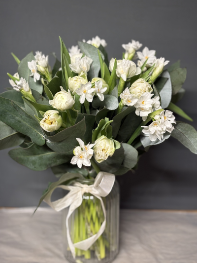 Maison Spring Vase - A stunning selection of spring flowers arranged in a vase.
This beautiful display is heavenly scented by the narcissus and is complemented by creamy white tulips and eucalyptus.