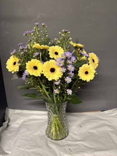Glorious Gerbera Vase - Glorious gorgeous Gerbera flowers matched with contrasting September Daisy and eucalyptus in a glass vase. Available in three sizes, the Classic size is shown.